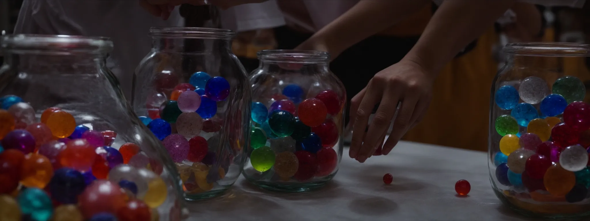 a person comparing two large, clear jars labeled 