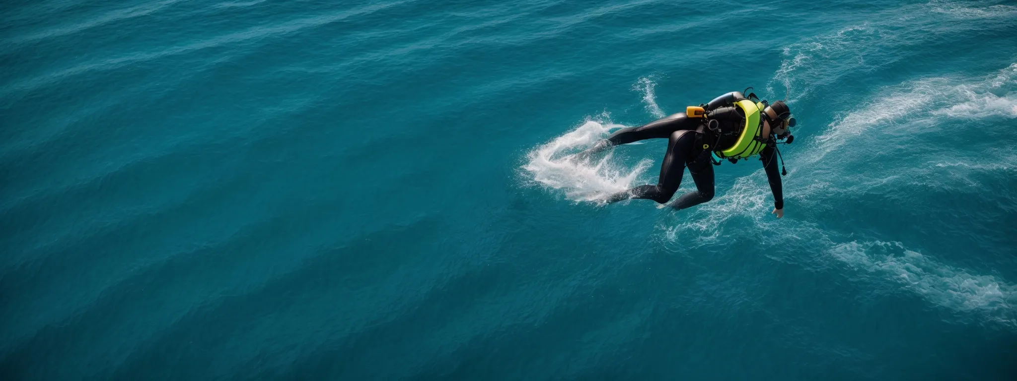 a person wearing diving gear jumps from a boat into the clear blue ocean representing an exploration into the depths of keyword research.