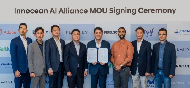 A group of eight men in business attire stands before a logo-adorned wall at the "Innocean AI Alliance MOU Signing Ceremony." One man holds an open document, symbolizing the promising collaboration with Search Atlas.