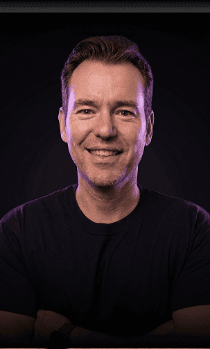 Smiling man using Search Atlas SEO software for keyword analysis.